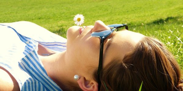 Woman in Grass with Daisy in mouth - learning Meditation